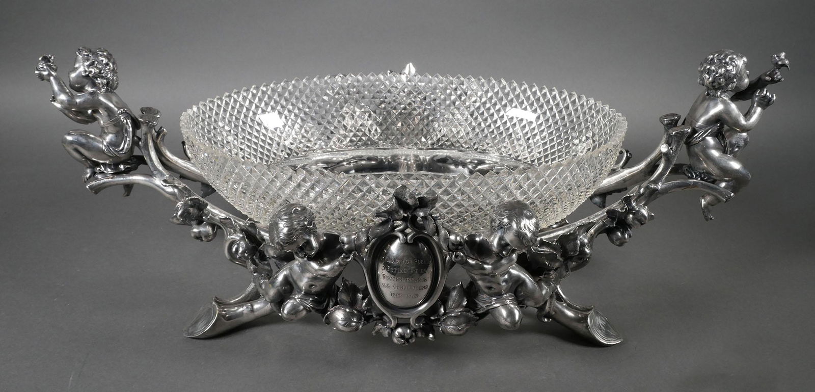 French Christofle Silverplate Centerpiece: French Christofle 19th century centerpiece with crystal bowl. Ornate floral, branch and leaf pattern and multiple putti around the sides and around a central cartouche, overall measurements 25 1/2" x