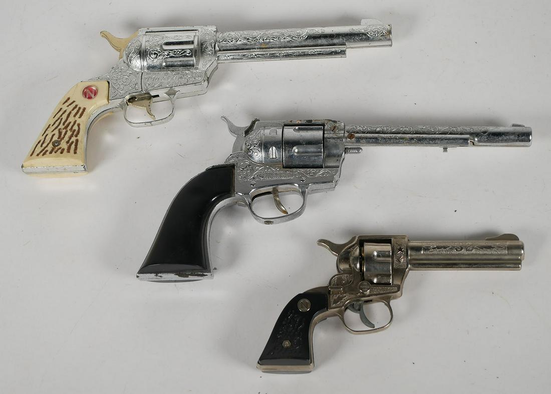 Three Nichols and Hubley Toy Cap Guns: Group of children's toy Western vintage mid century toy revolvers. Nichols Stallion 32, approx. 8 1/2 inches long. Nichols Mustang 500 Hubley Ric-O-Shay both approx. 12 inches long. This item can be s