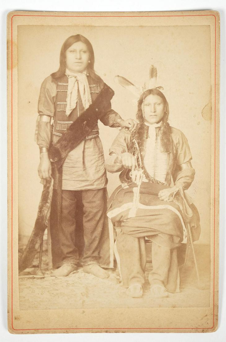 Buffalo Bill's Wild West Show Double Portrait: Stamped on the back "Goplo 55. Avenue Des Ternes, 55 Paris". An unusual image showing two front facing young Native American men. One man standing, wearing a jacket with beaded fringe over a tunic wit