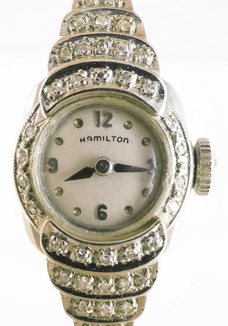 Antique Art Deco Hamilton Ladies 14K Watch: Hamilton watch face in an Art Deco style setting with small diamond accents, marked 14K on back, watch band marked Kestenmade Stainless. Length of watch 6", total weight 11.5 g. This item can be shipp