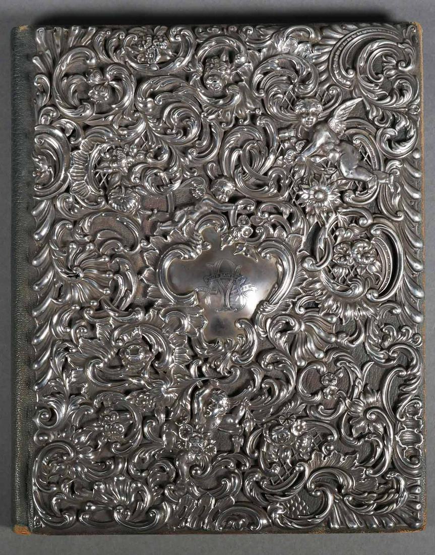 William Comyns Sterling Portfolio: Late 19th C. hallmarked silver with the Comyns four tipped oval hallmark. London sterling hallmark for 1895 book cover with a high relief repousse design incorporating cherubs with a dense and ornate 