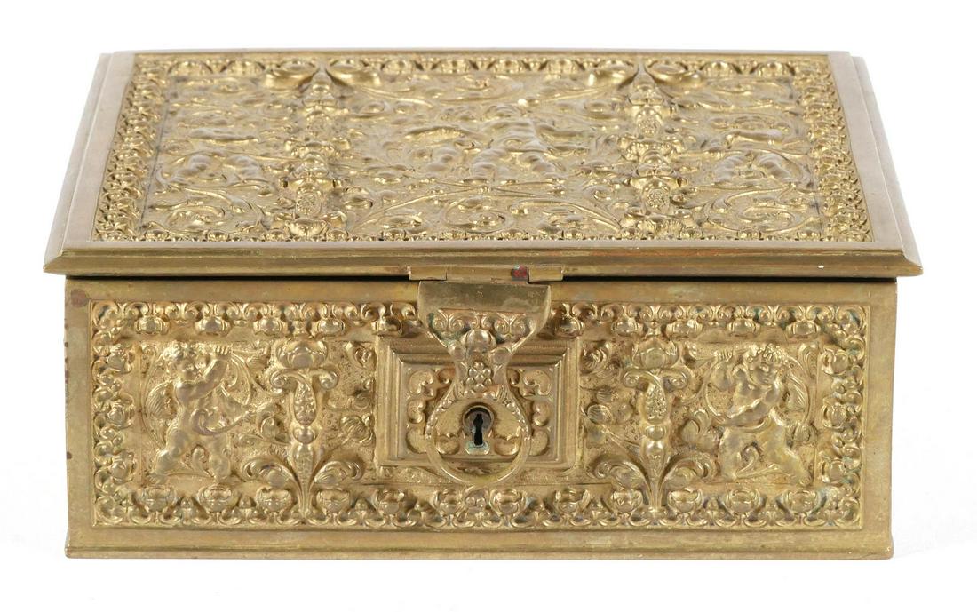 Antique German Erhard & Sohne Jewelry Casket: c. 1910 Rococo style repousse brass lift top trinket box with an overall ornate cherub and scroll pattern. Lined in deep red velvet. Overall approx. 8"x6"x3". This item can be shipped in-house.