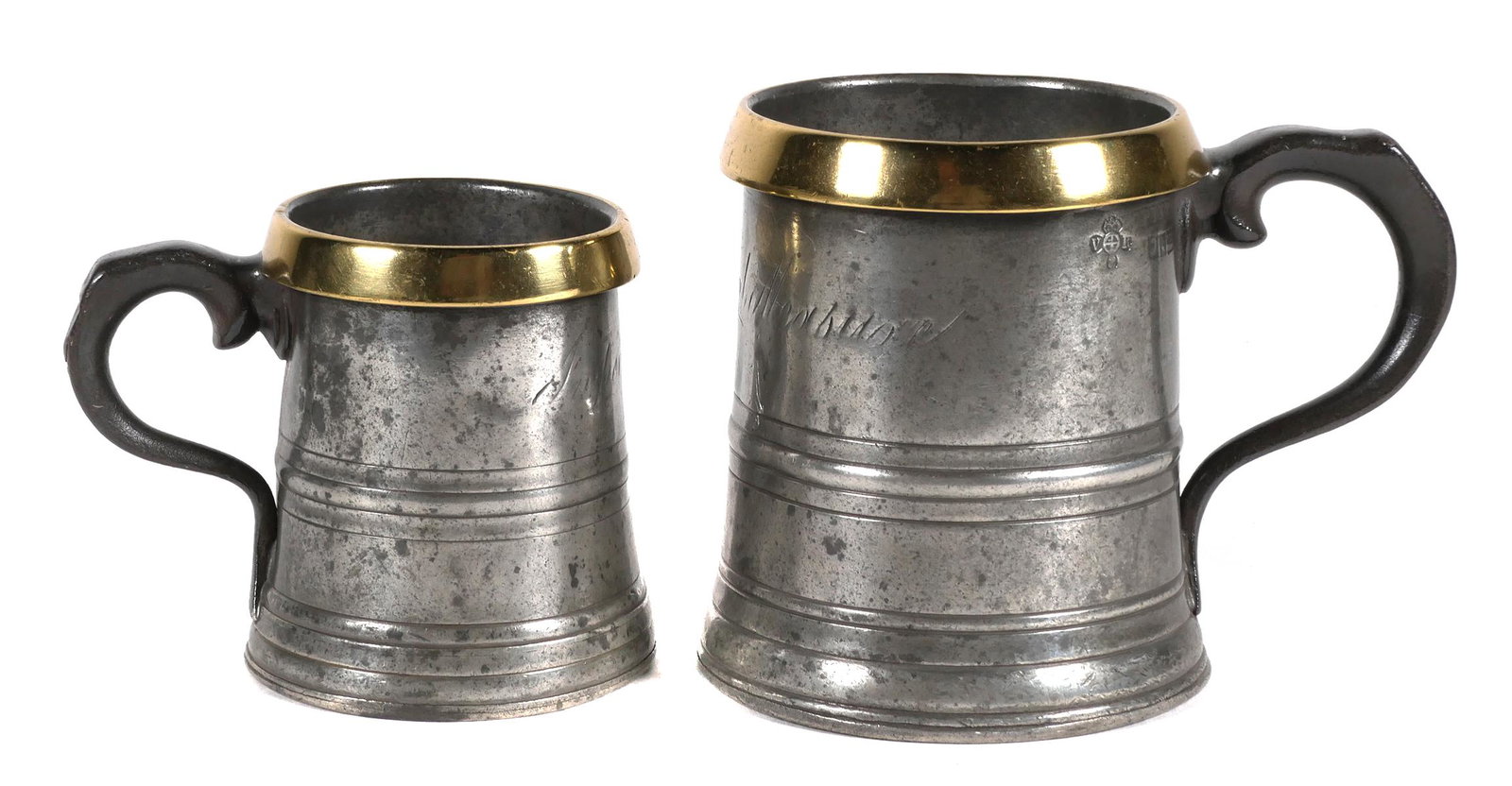 19th C. Pint and Half Pint Pewter Tankards: Two London pewter and brass handled rum Imperial Measure tankard mugs. Pewter with a brass rim, each marked with the Victoria Regina pre 1879 London City mark as well as an unknown maker's mark. Front