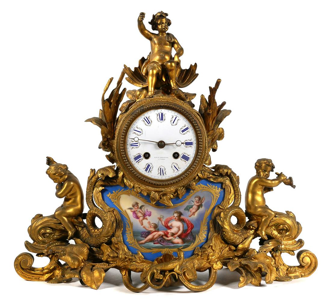 Antique Gilt FRENCH SEVRES Mantel Clock: Ornate French gilt brass mantel clock with Sevres style porcelain plaque with Amphitrite female figure riding dolphins with putti. Measures 13 1/4" x 15" x 6" (HWD). Clock face ESE Emanuel A. Paris. T