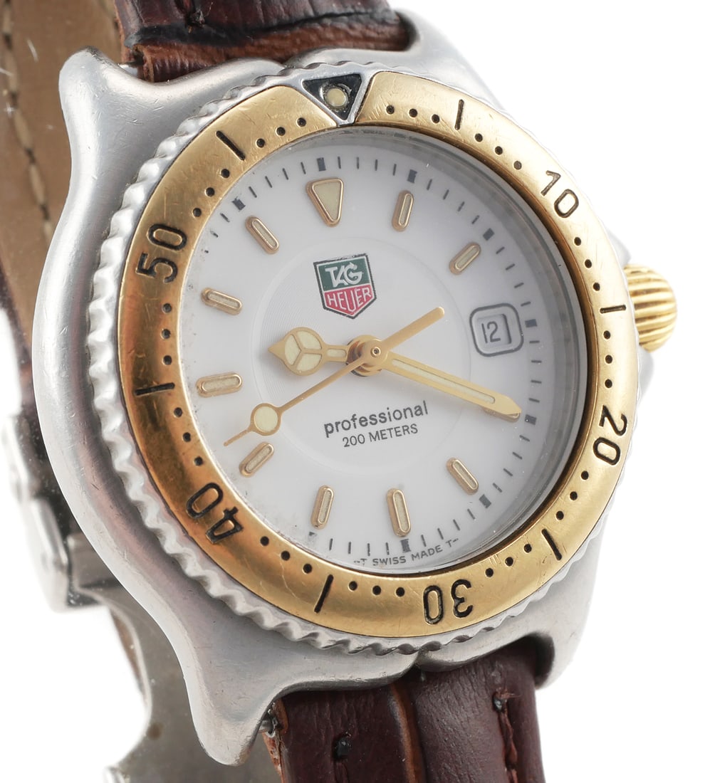 Women's TAG HEUER Professional 200 Watch: Ladies Tag Heuer Professional 200 Meters Swiss made wristwatch. Model WI 1350. Classic two tone model with yellow gold rotating bezel and crown. White dial has date display. Quartz movement. Leather b