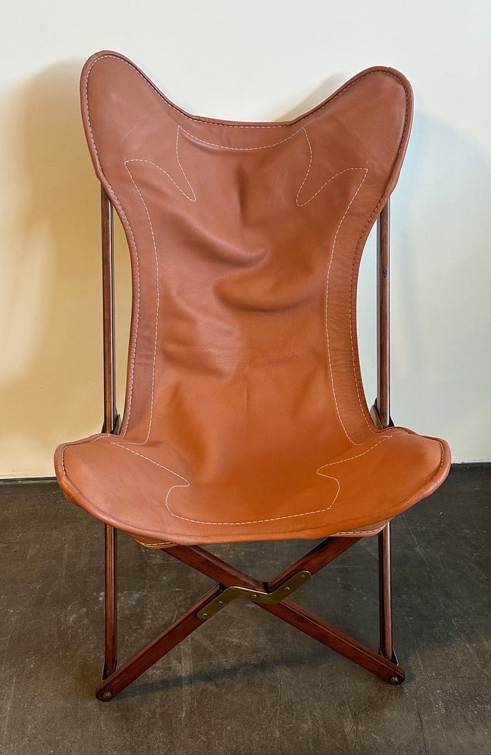 Ralph Lauren Sheltering Sky Camp Chair: Folding butterfly frame camp chair. Frame is beech solids with brass trim and in a burnished mahogany finish. Leather sling with welting and saddle stitching. Stitched Ralph Lauren label on back of le