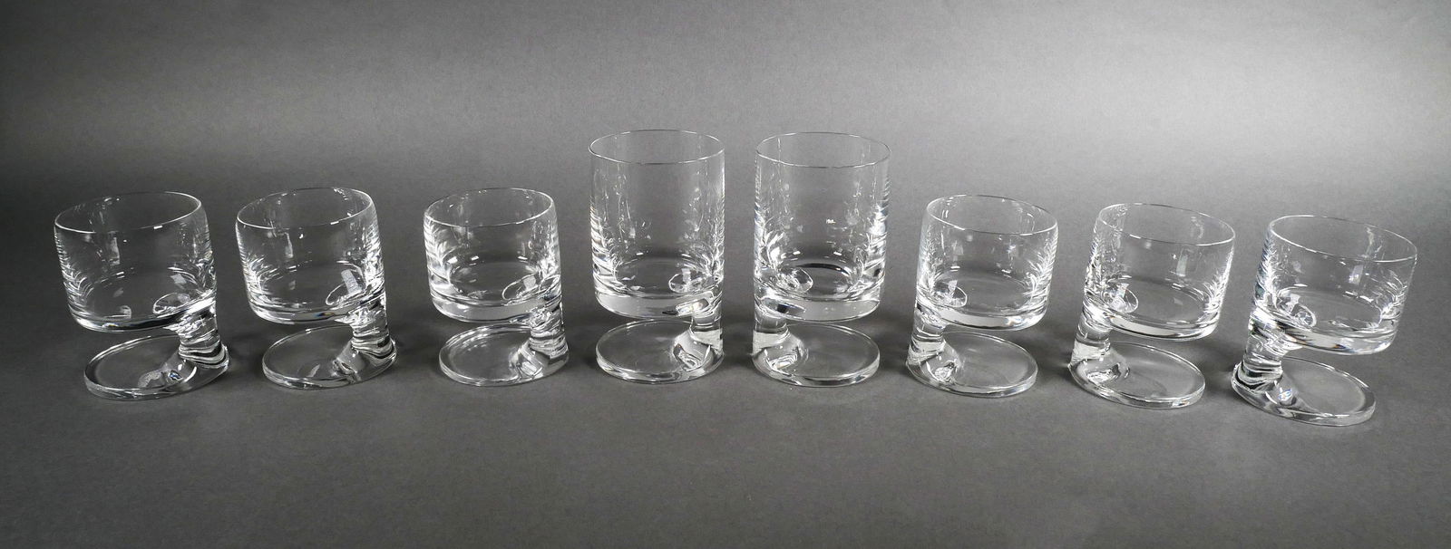 (8) JOE COLOMBO Smoke Glasses MCM: Eight smoke glasses by Mid Century Italian designer Joe Colombo. An avid drinking and smoker himself, Colombo sought to blend two pleasures into one gesture. The asymmetrical foot ensured a secure hol