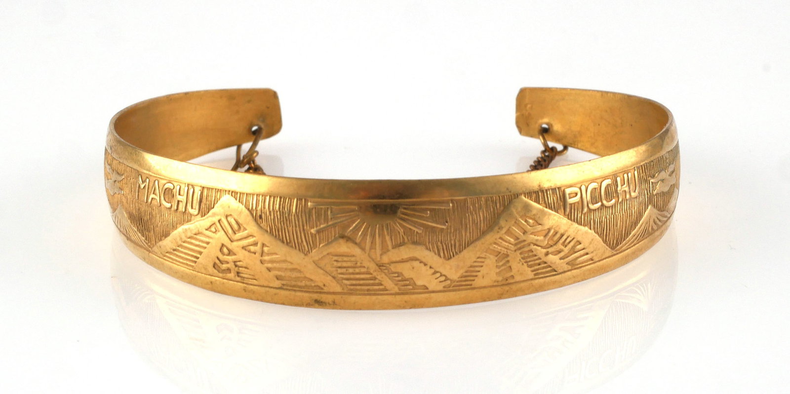 18K GOLD BRACELET: 18 karat yellow gold cuff bracelet with a safety chain. Design shows Machu Picchu. 7.7 grams total weight, interior circumference 6" total, 1" gap, 1/2" wide at the widest point. PLEASE NOTE: Credit c