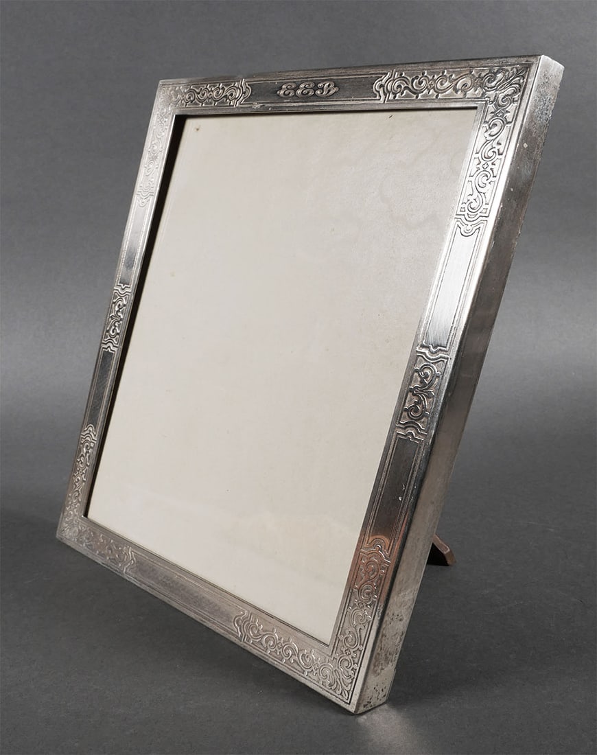 TIFFANY & CO Sterling Picture Frame: Early 20th century American Art Nouveau sterling silver and wood picture frame by, Tiffany & Co. with hand chased scroll motif. Back of frame is marked "Tiffany & Co. Makers Sterling Silver 21765A M".
