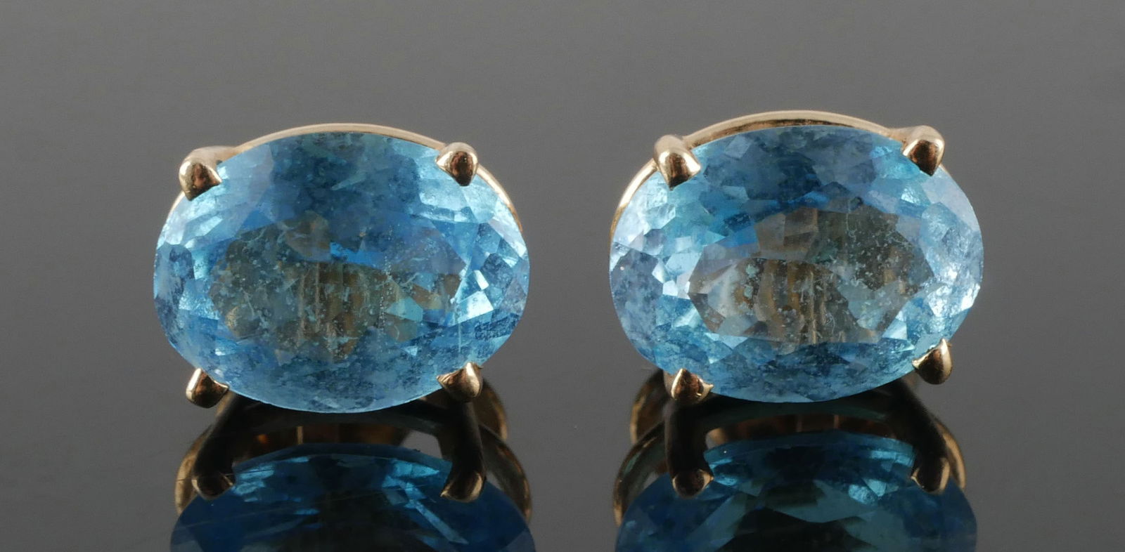 14K Blue Topaz Stud Earrings: 14 karat yellow gold pierced stud earrings. Test as 14k gold, 1.4 g tw. Stones test as topaz, approx. 6.3mm long. This item can be shipped in-house.