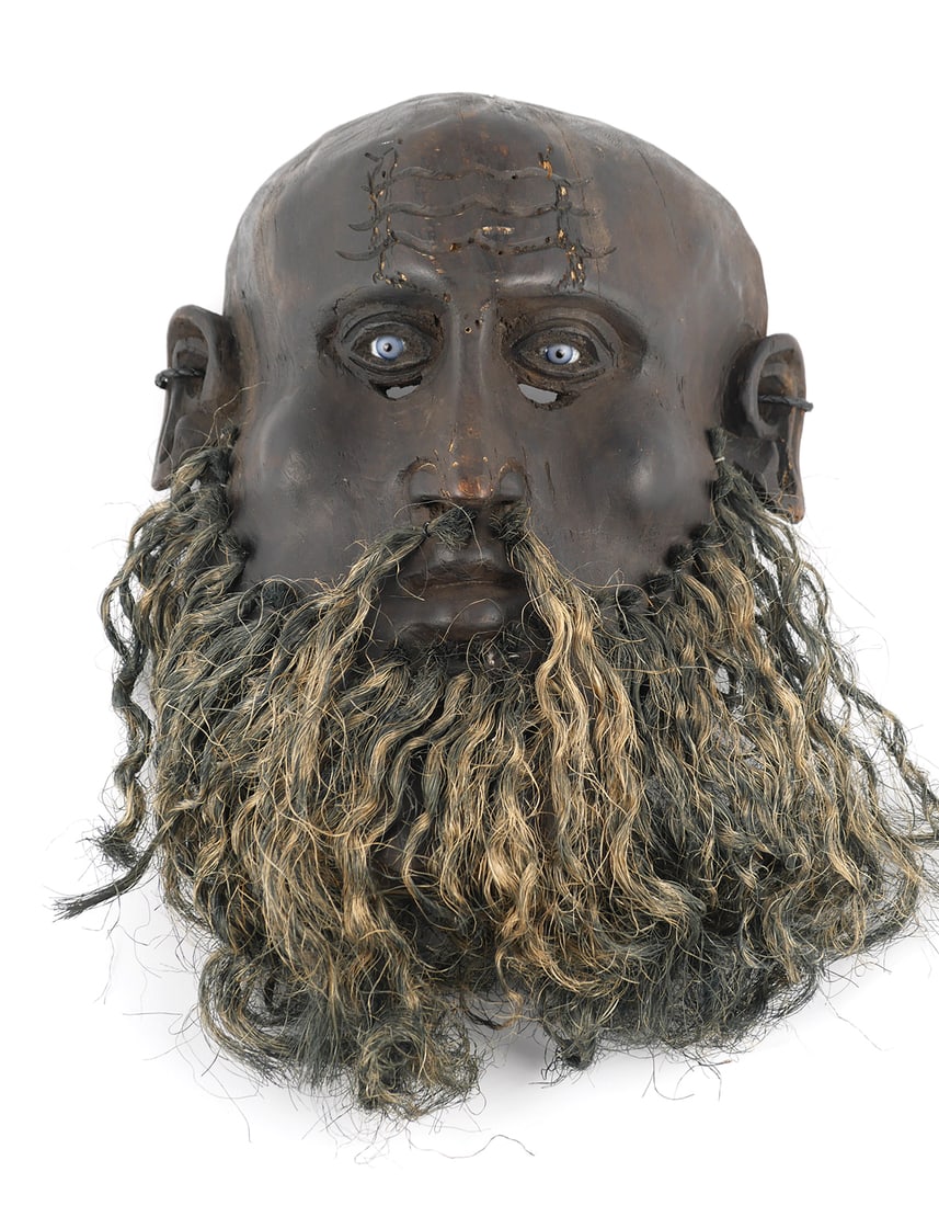 Folk Art Wood Mask Blue Glass Eyes: Carved and ebonized wood mask depicting a man with blue glass eyes and natural fiber wavy hair beard. Unknown origin, has elements reminiscent of Asian, White, and African masks. Open eye holes and ho
