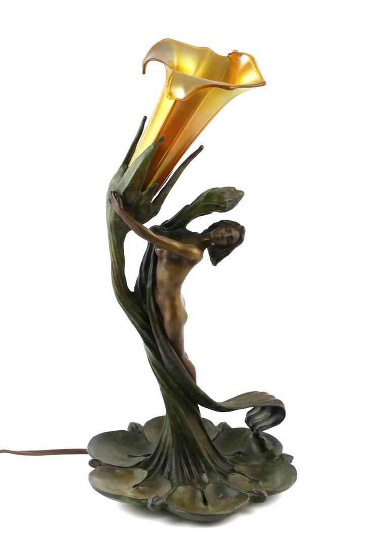 Art Nouveau Vintage Figural Lamp: Bronzed table lamp in the style of Gustav Gurschner, signed in mold on the underside. Art Nouveau woman emerging from lily pads, gold iridescent favrile aurene style glass lily flower shape shade. App