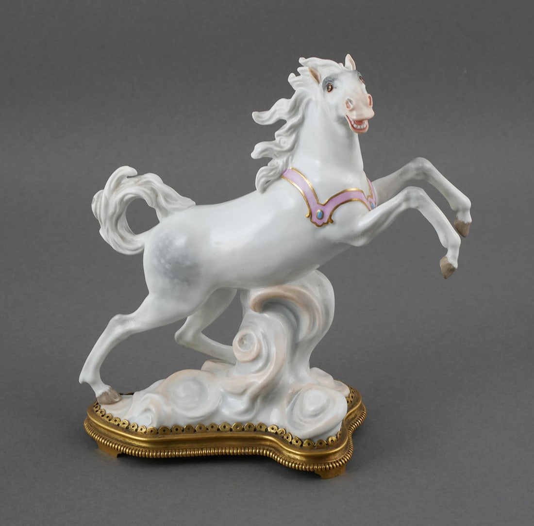 Meissen Porcelain Rearing Horse Figurine: This finely crafted Meissen porcelain figurine depicts a rearing horse with dynamic movement captured in exquisite detail. It stands approximately 8" tall and rests on a gilt-edged base. The underside