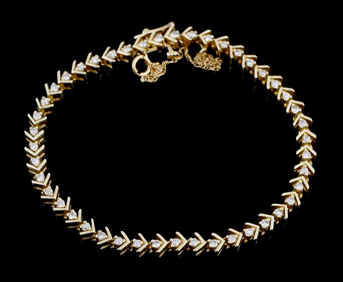 14K Gold Diamond Tennis Bracelet: 14 karat yellow gold and diamond tennis bracelet. V shaped links accented with diamonds, approx. .9 carats total. Marked 14k, 11.39 grams tw, approx. 7"L. This item can be shipped in-house.