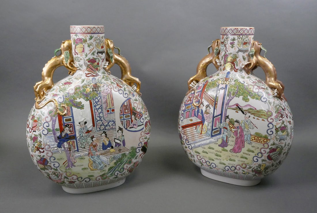 Pair Chinese Famille Rose Moon Flask Vase: Two large Chinese moon flask vase with gilt dragon handles and detailed hand-painted figural scenes on both sides in the Famille Rose palette. Six-character Qianlong mark in iron red on the base. Meas