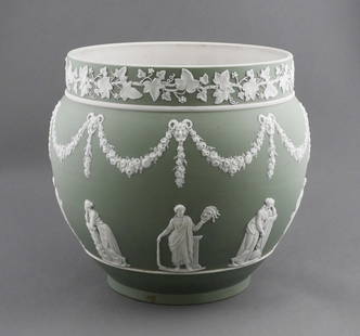 Antique Wedgwood Large Jardiniere: Jasperware planter, green ground with white applied sprigging. Ivy band across top rim, body decorated with Grecian or Roman style figures standing below a floral garland with faun heads. Late 19th or