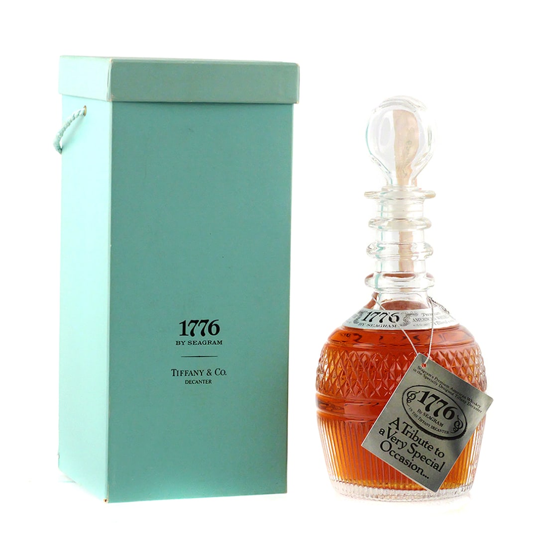 TIFFANY 1976 Seagram Whiskey Sealed: Tiffany & Co. American Bicentennial commemorative crystal decanter, 1776 by Seagram. Original blue gift box and storage bag. 11". PLEASE NOTE: This is a collectible bottle, and while it is in its orig