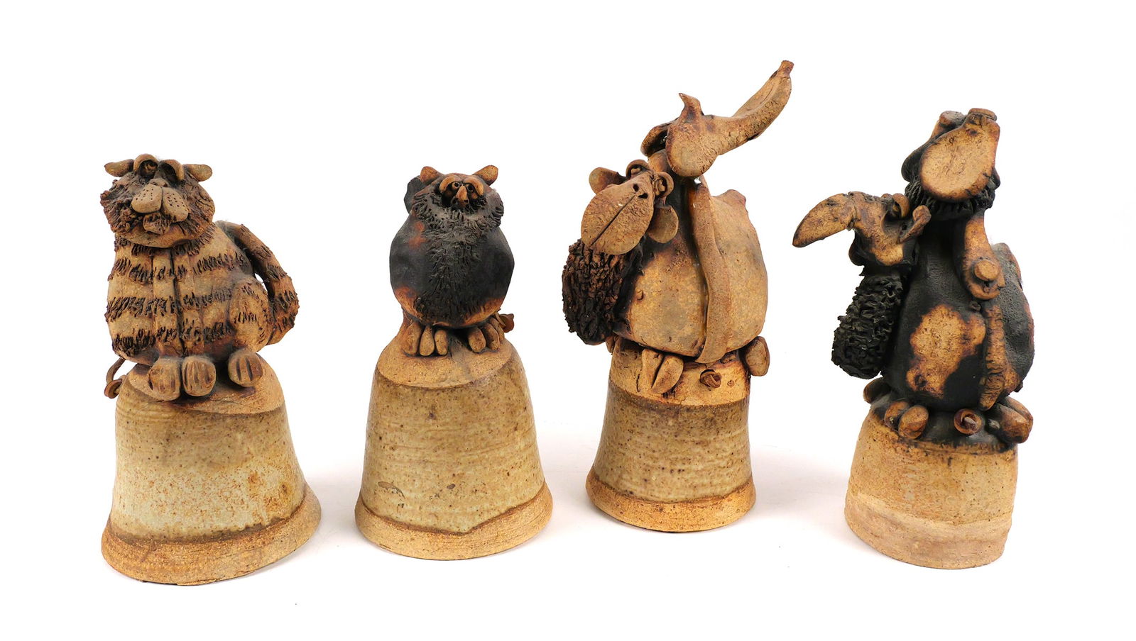 TODD WARNER, (4) Ceramic Bell Sculptures: Four ceramic bells topped by an owl, two camels and a cat by sculptor Todd Warner (American, b. 1945). They measure 6-1/4" to 8" high. This item can be shipped in-house. Multiple lot combined shipping