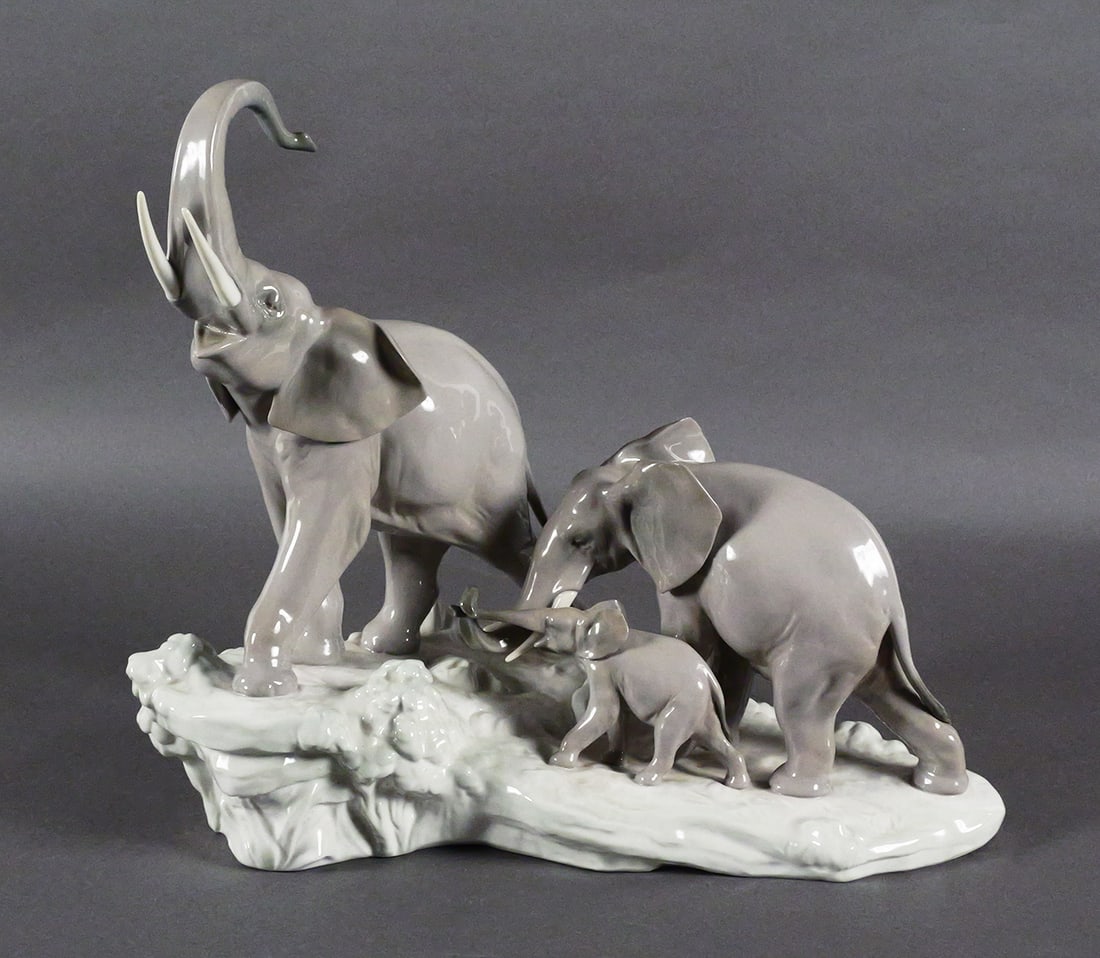 Lladro Elephants Walking Porcelain Group #1150: Large Lladro glazed porcelain sculpture titled "Elephants Walking," model 4764, designed by sculptor Fulgencio Garcia. Depicts a family of three elephants-an adult, juvenile, and calf-walking together
