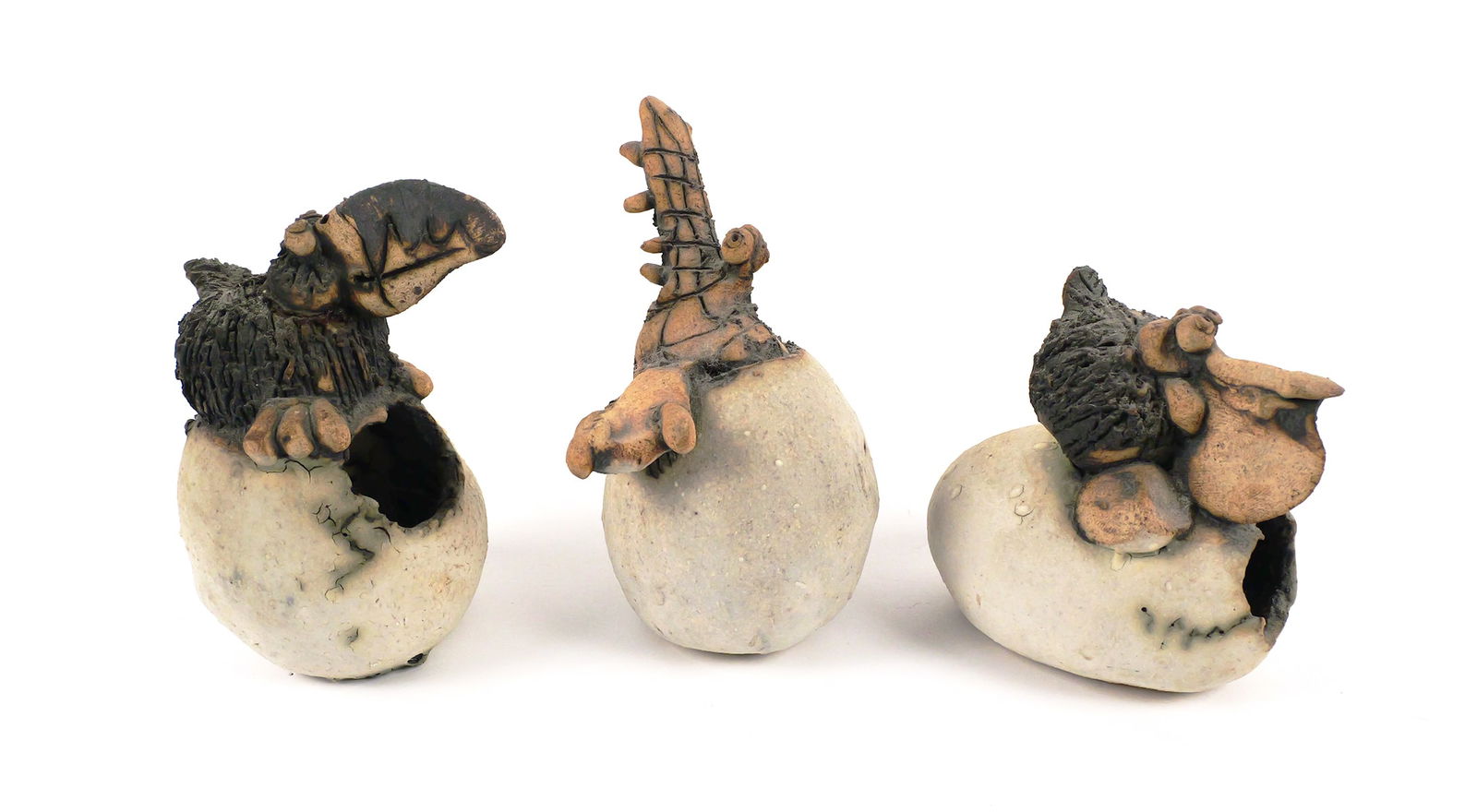 TODD WARNER, (3) Egg Hatchling Sculptures: Three ceramic art sculptures of eggs hatching a toucan, a pelican and an alligator by sculptor Todd Warner (American, b. 1945). All three signed and dated 1978. They measure 3-1/2" to 4-1/2" high. Thi