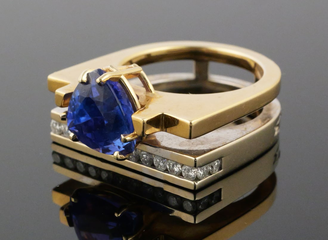 14K Gold Tanzanite Diamond Ring Marley: 14 karat yellow and white gold ring set with a trillion cut tanzanite and diamonds. Two tone modernist design, central trillion stone with fifteen accenting diamonds in a wrap around design. "M"