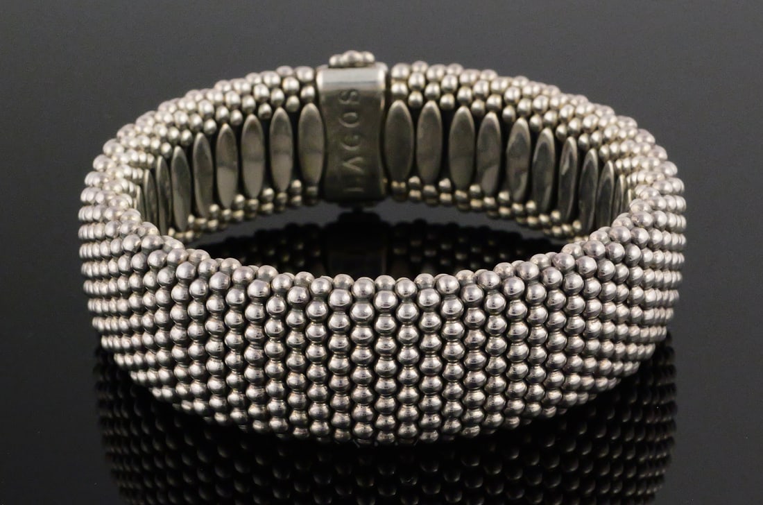 LAGOS CAVIAR Sterling Silver & 18K Gold Bracelet: Stunning Lagos 925 silver bracelet with 750 gold logo. Fits 8" wrist. Measures about 7/8" wide, weighs 144 grams. This item can be shipped in-house. Multiple lot combined shipping may require 3rd