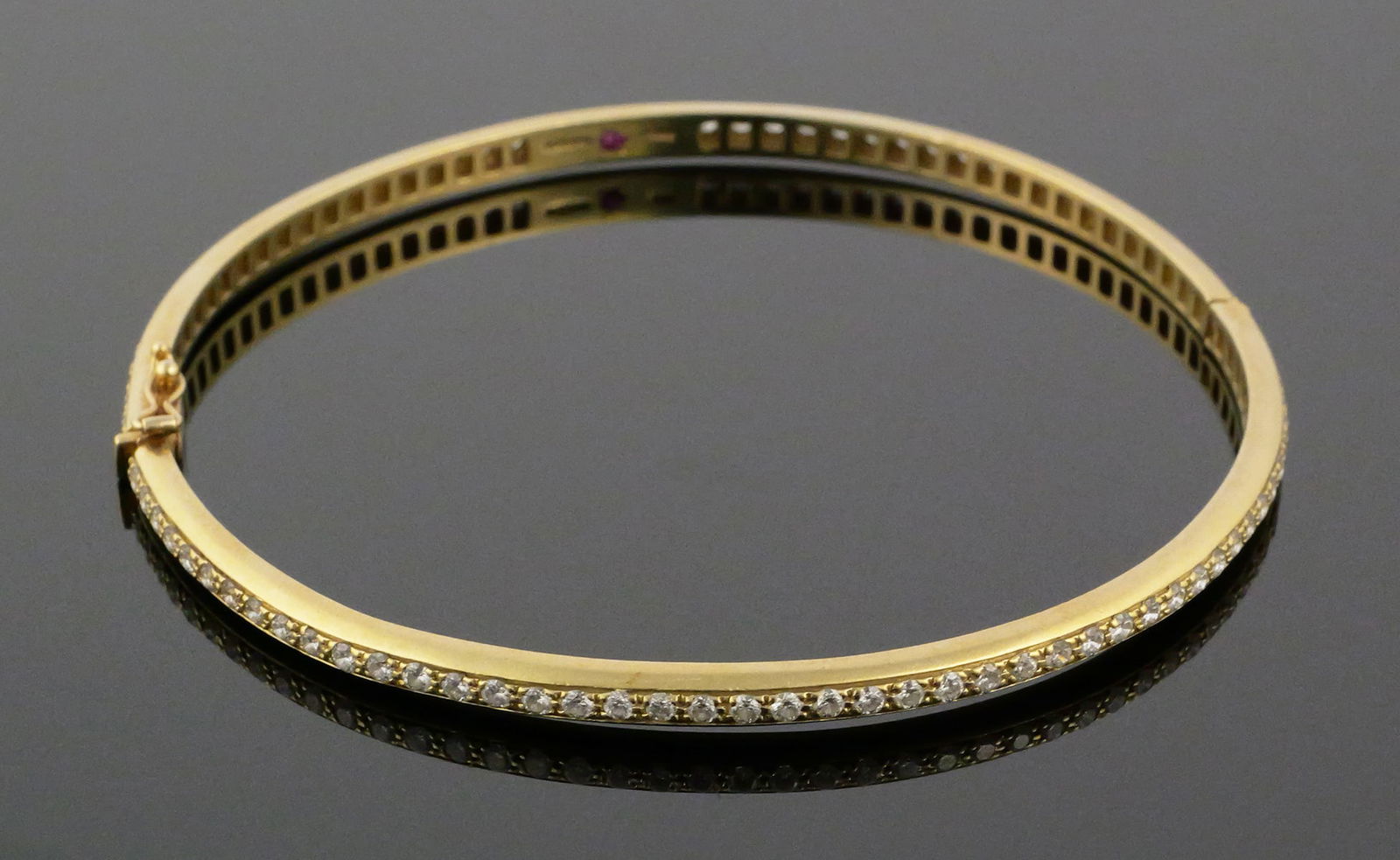 18k Gold Diamonds Eternity Bracelet: More than 90 prong-set ~2-point diamonds surround an 18k yellow gold hinged eternity bracelet. Inside circumference about 8-1/4". Ruby mounted between purity mark and Italian hallmark (possibly