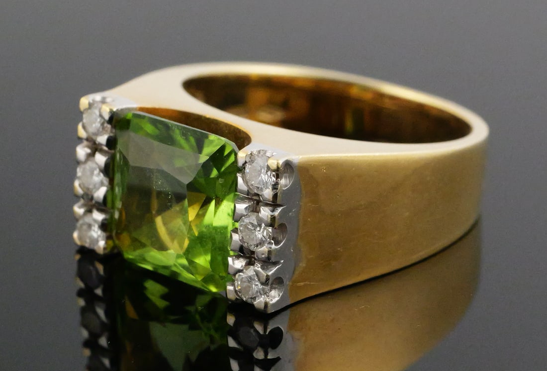Vintage 18k Yellow Gold Peridot Ring: Size 7 vintage 18k gold ring with six diamonds flanking a 9mm square peridot (about 5 carats). Weighs 10g total. This item can be shipped in-house. Multiple lot combined shipping may require 3rd Party