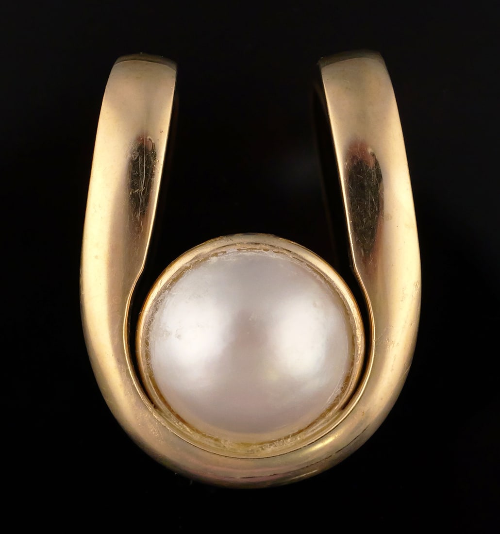 14K Gold Mabe Pearl Pendant: 14 karat yellow gold slide pendant set with a central mabe pearl. 14 k yg, 7.6 grams tw. Approx. 7/8"wide, 1-1/8"L. This item can be shipped in-house. Multiple lot combined shipping may require 3rd