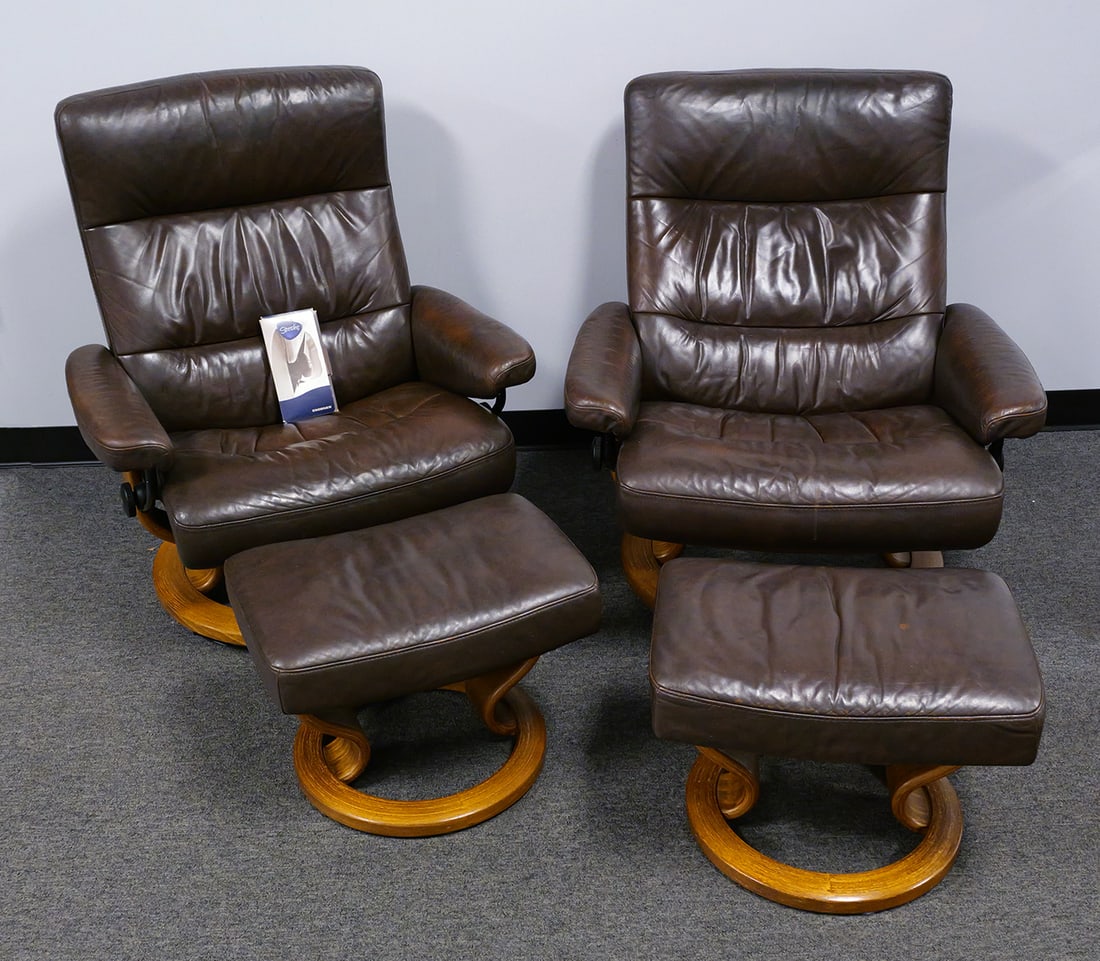 Pair Ekornes Stressless Chairs & Ottomans: Pair of modern Ekornes stressless reclining chairs with ottomans. Wood base, brown leather. Chairs are approx. 33"W x 38-1/2"H. This item will need to be shipped by a packing company of your choice.