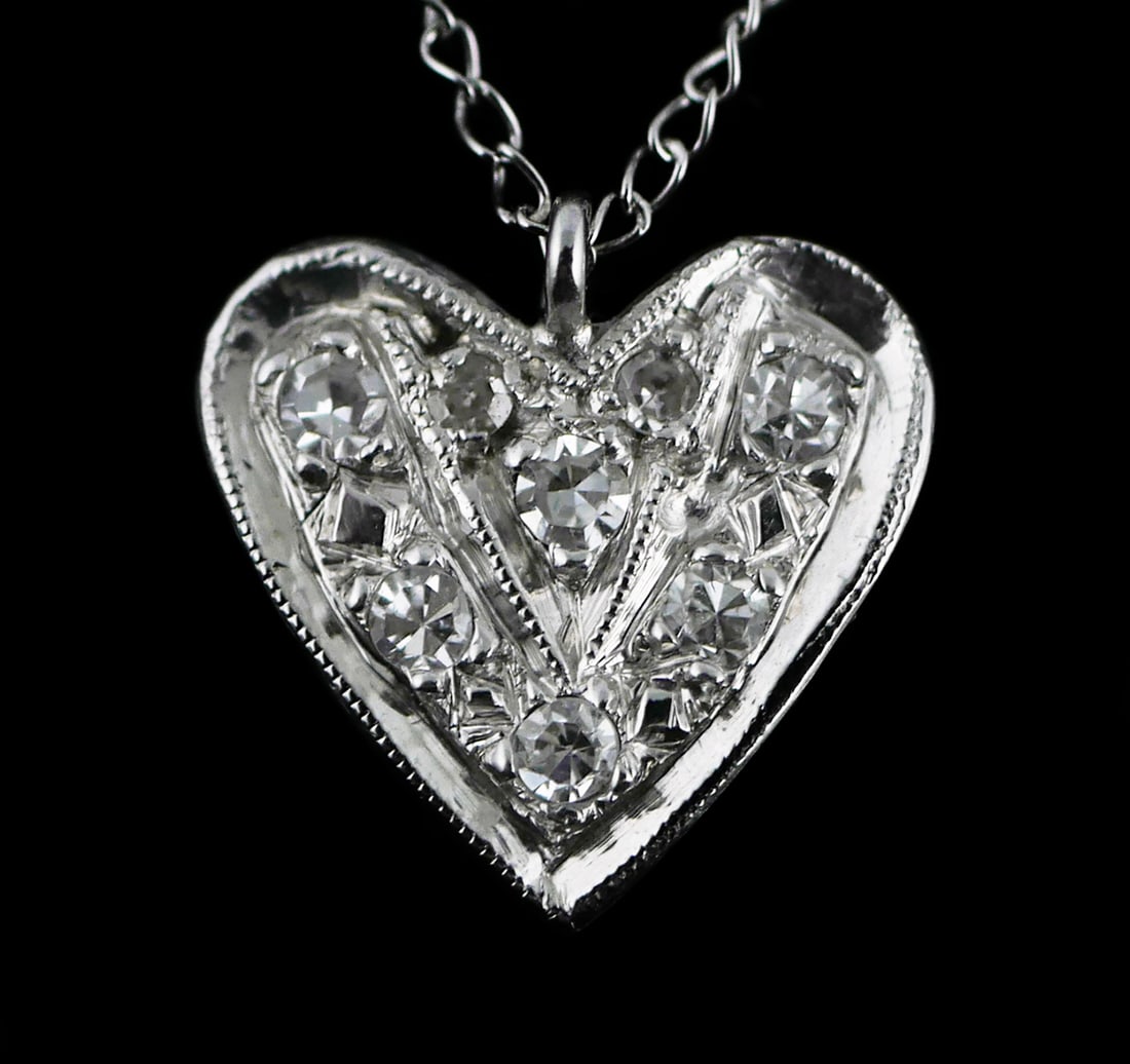 14K Gold Diamond Heart Pendant Necklace: 14 karat white gold Art Deco inspired diamond studded heart pendant on a delicate 14k wg chain. .99 grams tw, .15 carats diamonds total, 16" chain, pendant approx. 3/8" x 3/8". This item can be