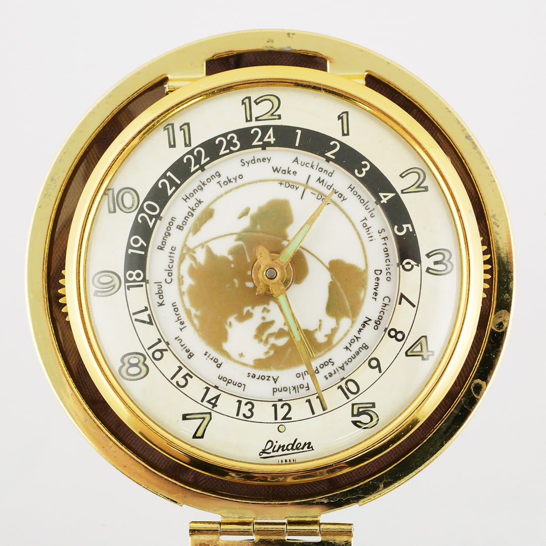 Vintage Linden World Time Travel Clock: Mid century Linden Travel Alarm clock with world map face and time zone display, round hard shell case. Approx. 3"wide closed. This item can be shipped in-house. Multiple lot combined shipping may