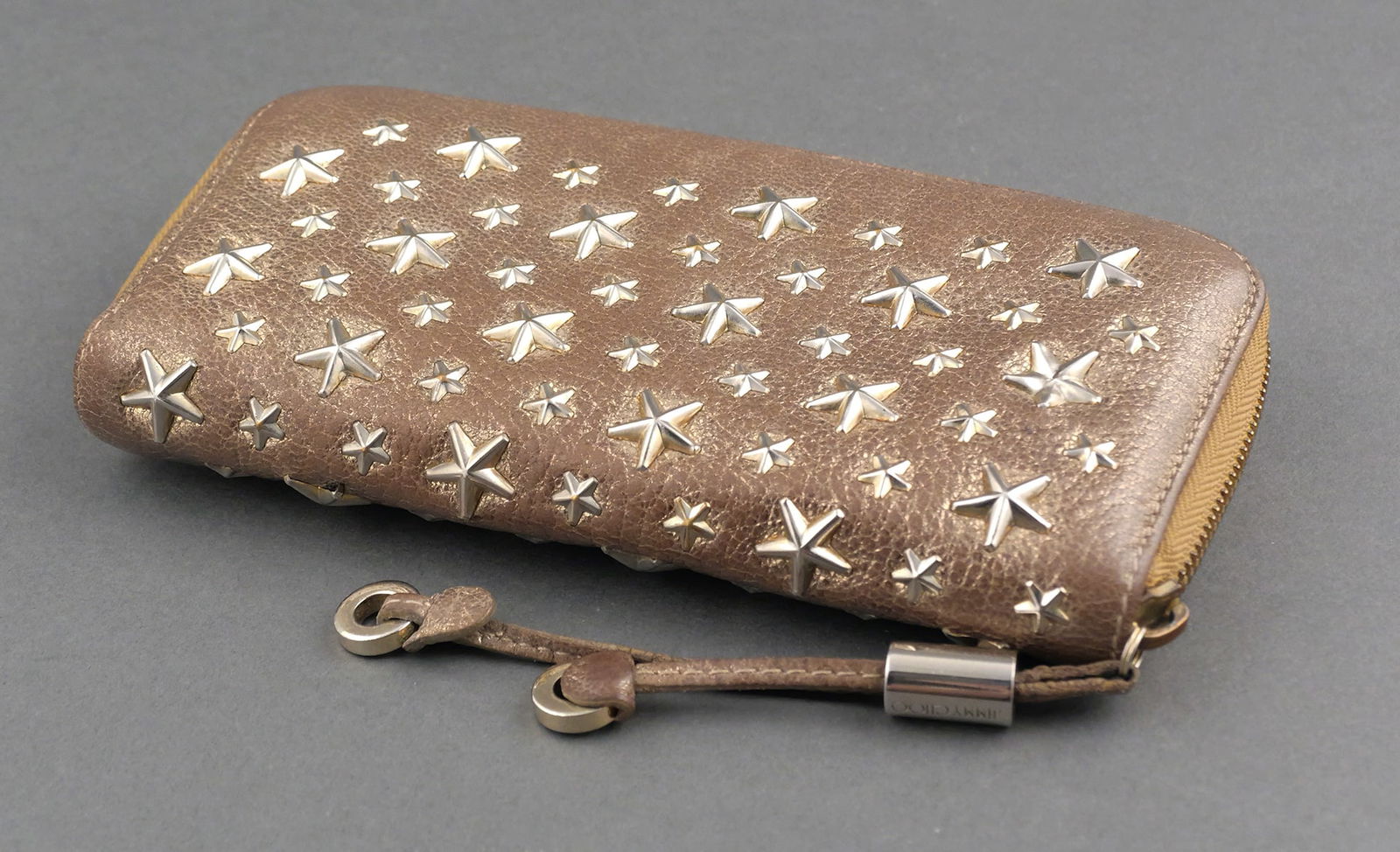 Jimmy Choo Filipa Star Gold Long Zip Wallet: Jimmy Choo Filipa Star Studded Gold Metallic Leather Long Zip Around Wallet. Measures 7-1/2" x 4-1/4". This item can be shipped in-house. Multiple lot combined shipping may require 3rd Party shipping.