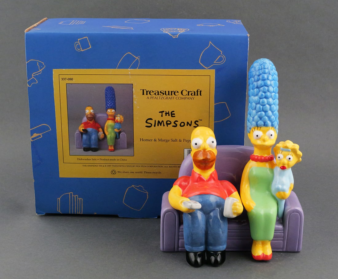 The Simpsons Salt & Pepper Shakers MIB: Homer, Marge, and Lisa with their couch. By Treasure Craft Pfaltzgraff, novelty ceramic salt and pepper shakers, mint in original box. Couch approx. 5-3/4"L, Homer approx. 5"H, Marge holding Maggie