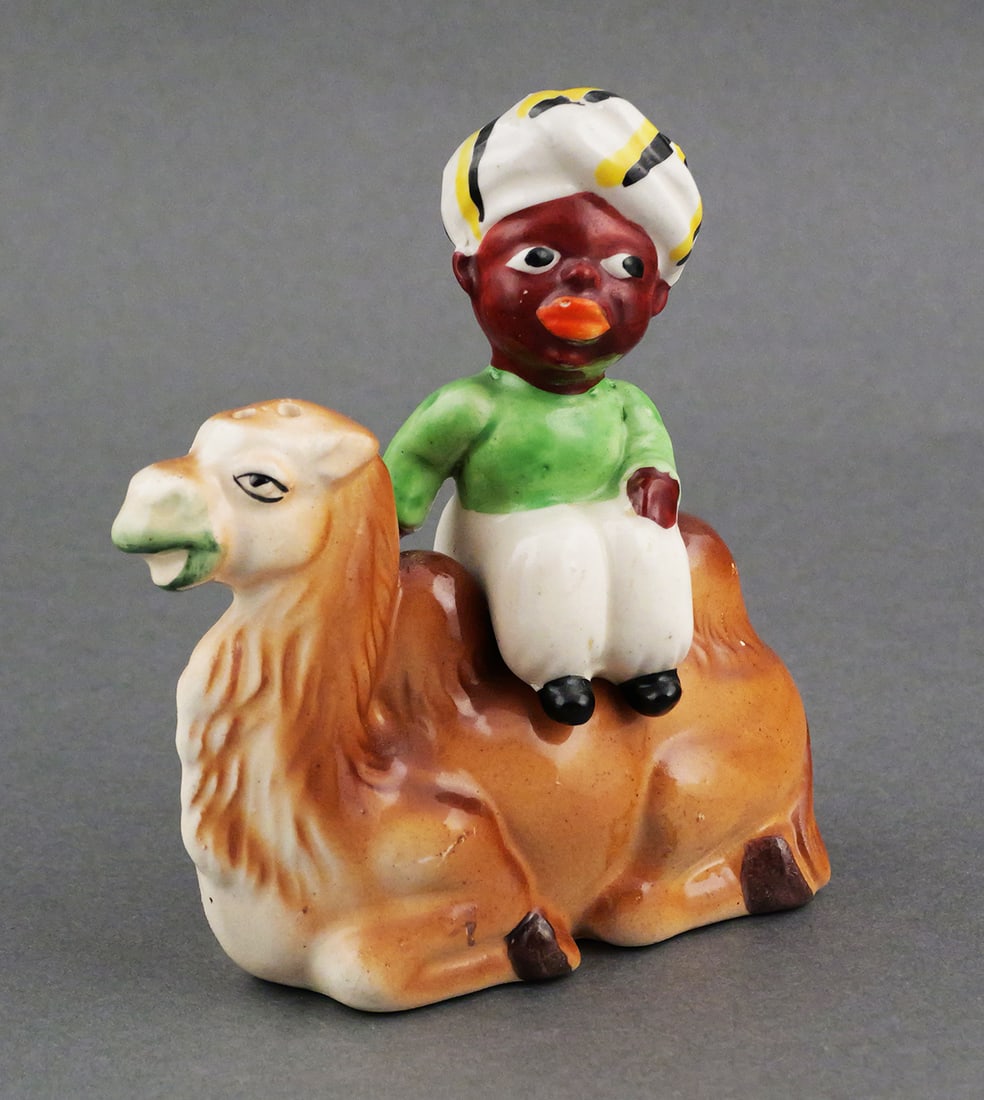 Vintage Black Americana Salt & Pepper Set: Early to mid 20th century figural novelty salt and pepper shaker set. Black man with exaggerated features and wearing a turban sitting between the humps of a camel. Man marked "Japan", camel marked "M