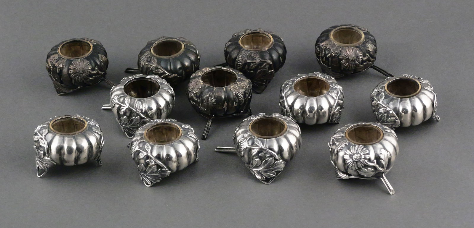 Antique Japanese Sterling Salt Cellars (12): 12 sterling silver pumpkin or Kabocha-shaped salt cellars with flower decoration, possibly Japanese. Art Nouveau era, presumably made for the American or Continental market. Measure approximately: 2" 