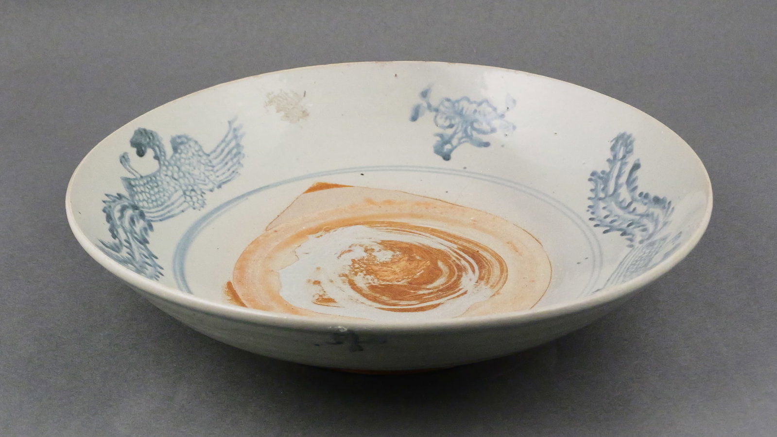 Chinese Late Ming Swatow Phoenix Bowl: Large blue and white ceramic bowl or dish attributed to the Swatow (Zhangzhou) kilns, circa late Ming period (late 16th to early 17th century). Decorated with phoenix and flowers around central medall