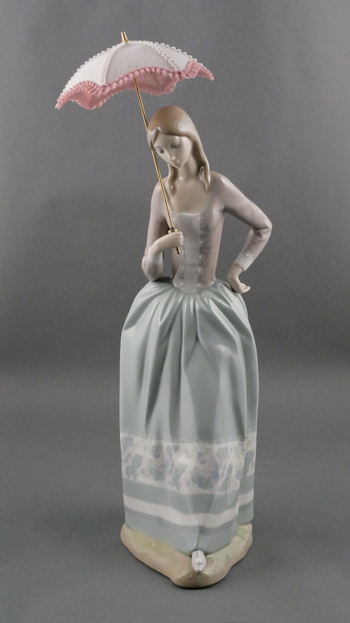 LLADRO 19" Lady with Pink Umbrella: Retired Porcelain Lladro, #4805, Lady with Pink Umbrella Parasol. Measures approx 19" tall. This item will need to be shipped by a packing company of your choice. We maintain a list of reliable