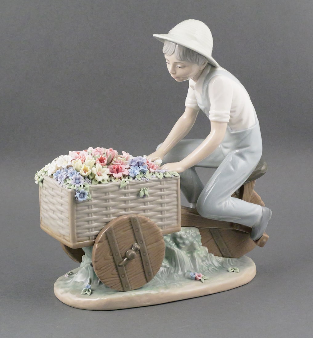 LLADRO Flower Peddler Boy Figurine: Lladro Figurine #5029 Flower Peddler, Boy Peddling Flower Cart. Measures 4-1/4" x 9" x 10-1/4" tall. This item will need to be shipped by a packing company of your choice. We maintain a list of reliab