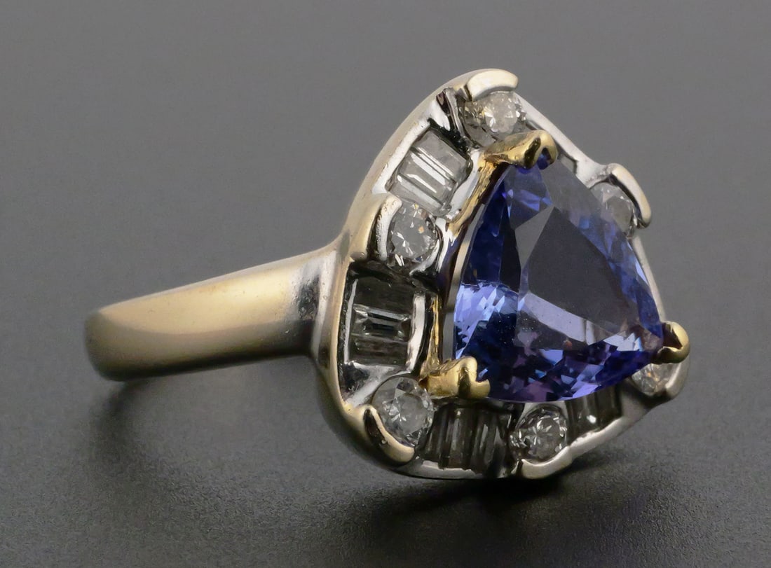 18k Gold 3 ct TANZANITE Diamond Ring: 18k white gold ring with 2.99 ct triangle VVS tanzanite, surrounded by six round and 18 baguette diamonds, total diamond weight about .75 ct. Weight 8.9 grams. Size 7. This item can be shipped