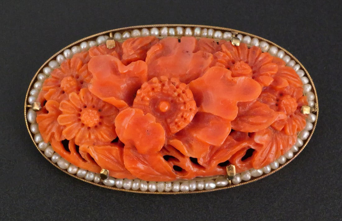 Antique 14k Gold Carved Coral Brooch Pin: Early 20th century brooch, with carved red coral flowers and leaves, prong-mounted on marked 14k gold brooch, bordered by seed pearls. Measures 1-7/8" wide. Total weight 13.3 grams. This item can be