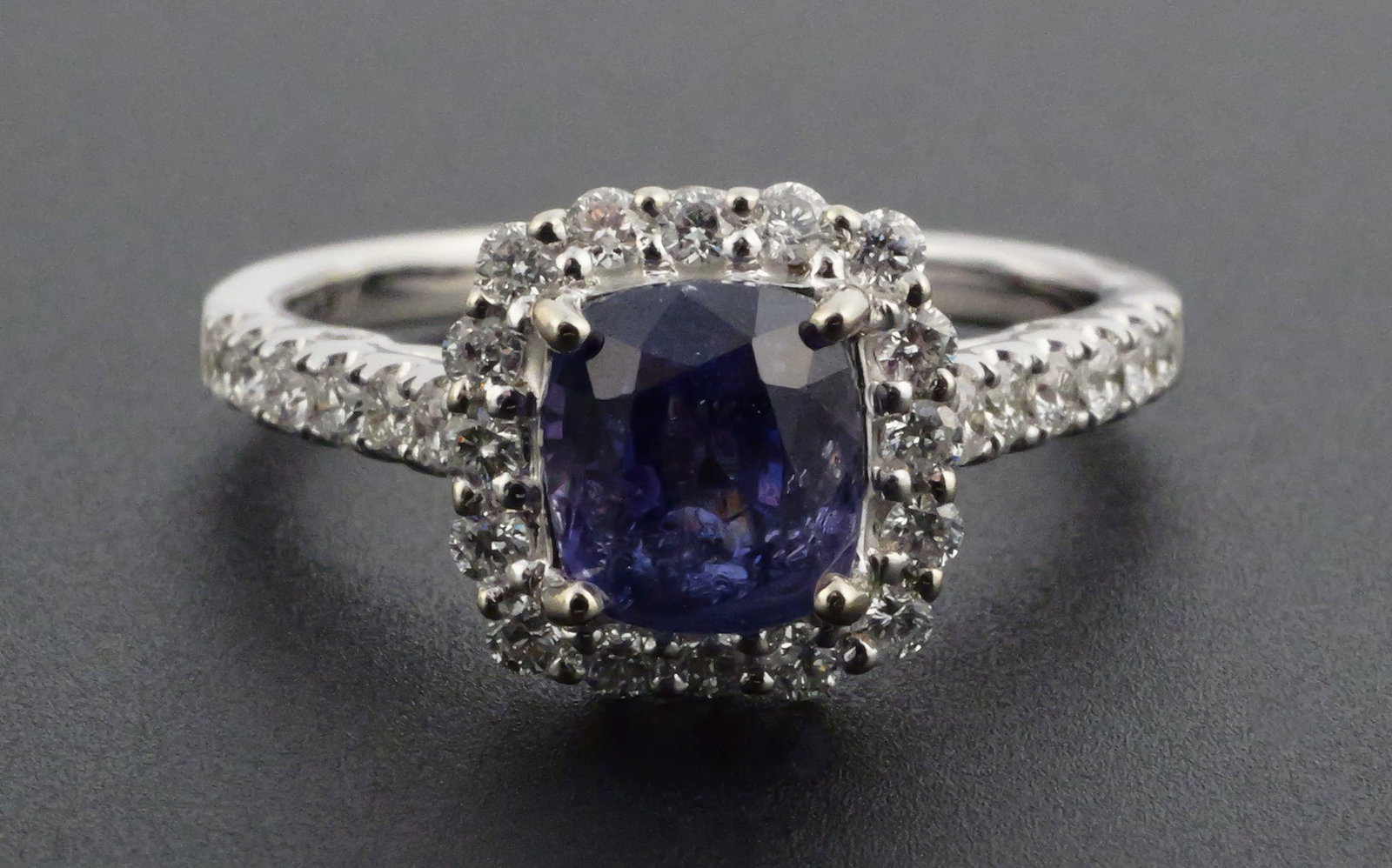 18K Gold Sapphire & Diamond Ring: 18K white gold ring set with one cushion-cut natural purple sapphire weighing approximately 1.77 carats and 28 round brilliant-cut natural diamonds totaling approximately 0.50 carats. Diamonds are gra