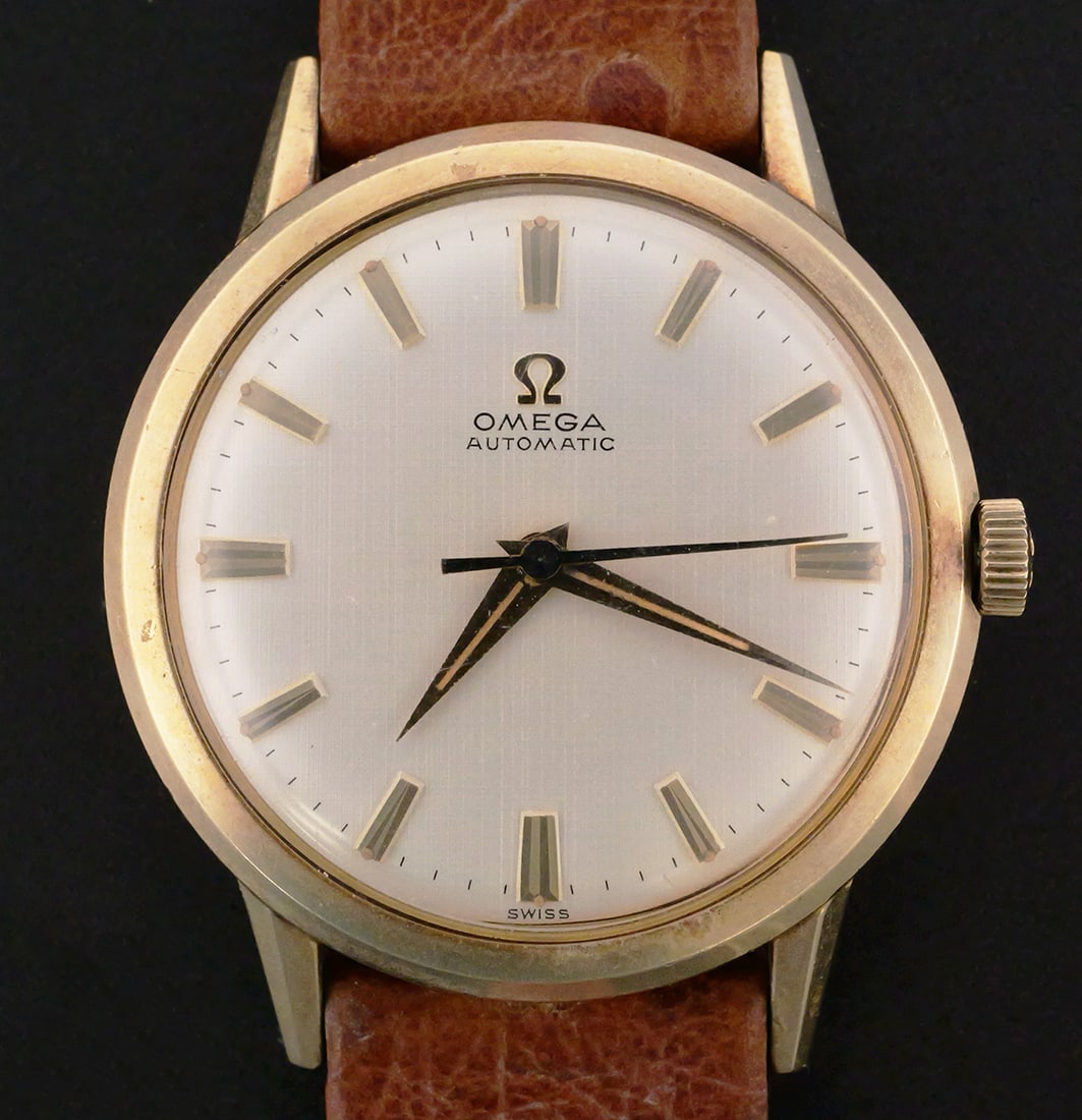 Omega Automatic Gold-Filled Wristwatch: Omega Automatic men's Swiss wristwatch, circa 1950. Features a silver-tone dial with applied gold-tone hour markers and matching hands in a 34 mm two-tone round case with a yellow gold-filled bezel. C