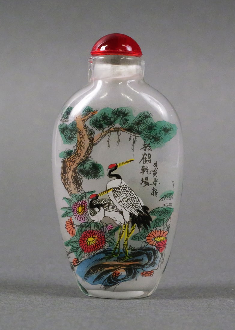 Reverse Painted Chinese Snuff Bottle with Stopper: Reverse painted Chinese Snuff Bottle with stopper. One side reads, "Two Cranes Singing in the Greenery", the other, "May the Pine and Crane Lengthen Your Years." Measures approx 3" x 1-1/2". This