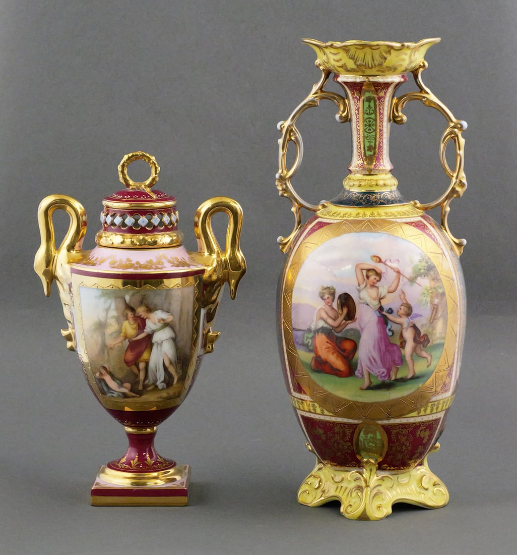 (2) Royal Vienna Amphora Form Urns: (2) Royal Vienna Amphora Form Urns. Both have the Royal Vienna beehive mark on their bases. Largest piece measures approx 13-1/2" tall, 5-3/4" wide. This item will need to be shipped by a packing comp