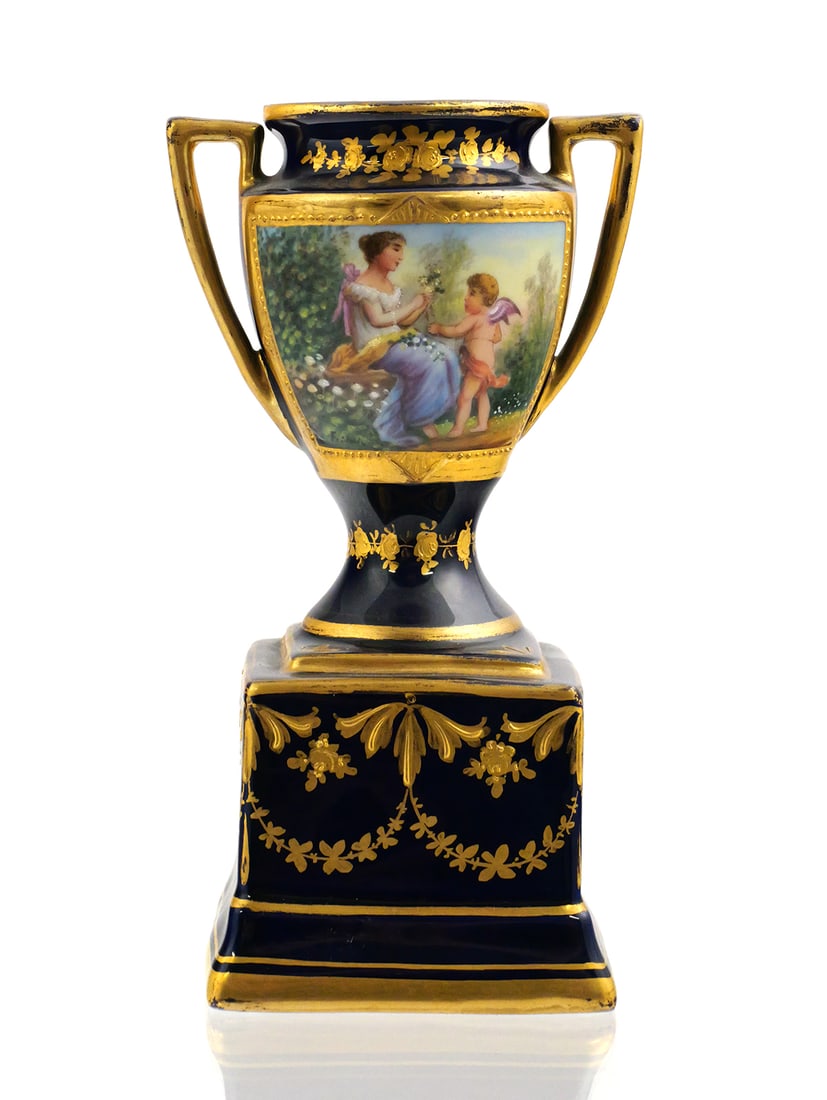 Royal Vienna Amphora Form Open Urn: Royal Vienna Amphora Form Open Urn mounted on block base, gilt accents and trim on cobalt glazed ground. Blue beehive stamp on base. Measures approx 6-1/8" x 3-/12". This item can be shipped in-house.