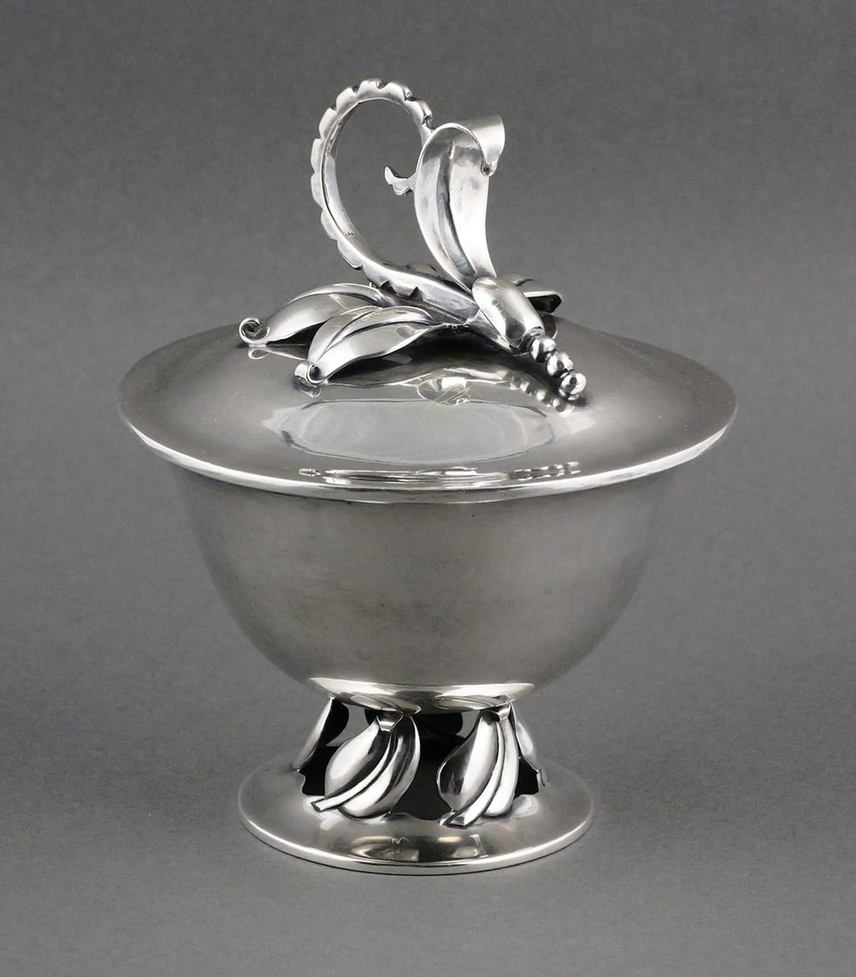 Sterling Covered Bowl Taxco Jensen Design: Vintage covered bowl in the style of the Georg Jensen Blossom pattern. Open leaf design foot, cover decorated with a Jensen inspired stylized floral knop handle. Marked "Handwrought Los Castillo Taxco