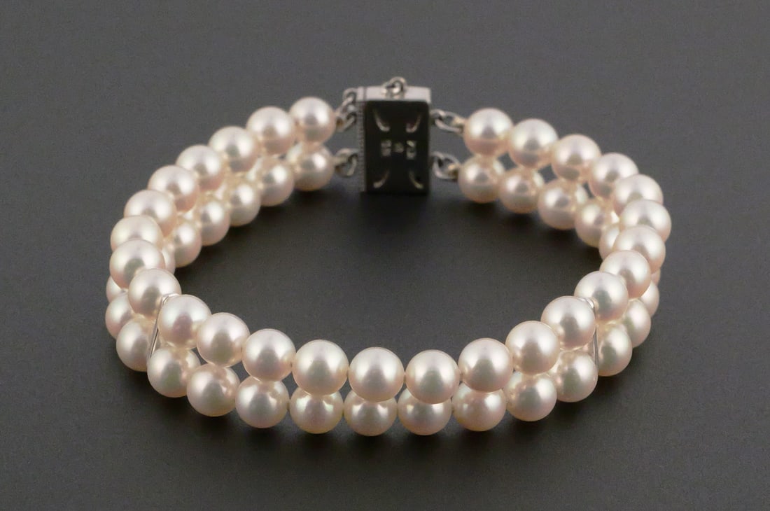 MIKIMOTO 14k Gold Dbl-Strand Pearl Bracelet: 14k white gold clasp signed with Mikimoto "M" mark. Measures 6-3/4" Pearls about 5.5mm. This item can be shipped in-house. Multiple lot combined shipping may require 3rd Party shipping.