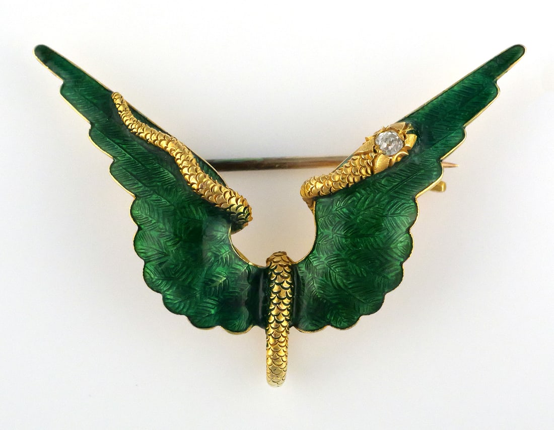 14K Gold Green Enamel Diamond Serpent Brooch: 14K+ yellow gold brooch with green enameled decoration and applied textured serpent motif, snake eye set with a diamond. Approximately 1-3/4" wide. Overall weight 7.1 grams. This item can be shipped
