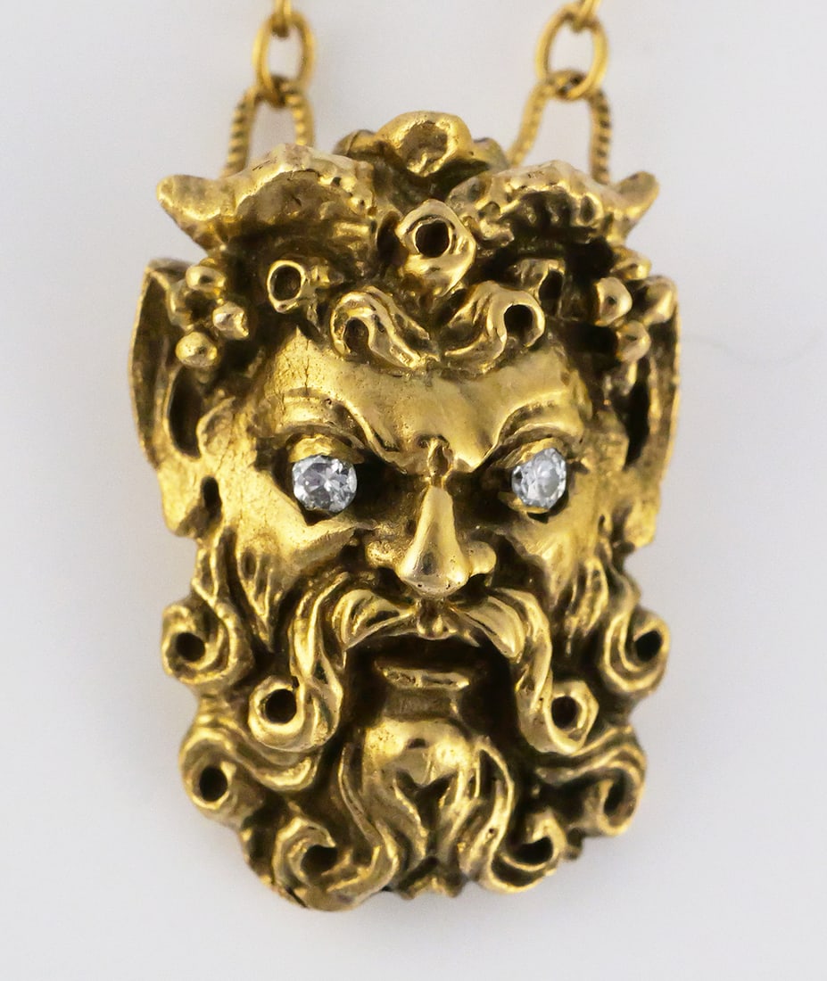 14K Gold Sapphire & Diamond Figural Brooch: 14K yellow gold brooch featuring a rope-twist bar set with five faceted blue gemstones, possibly sapphire and a suspended figural mask depicting a bearded mythological male with two diamonds set as